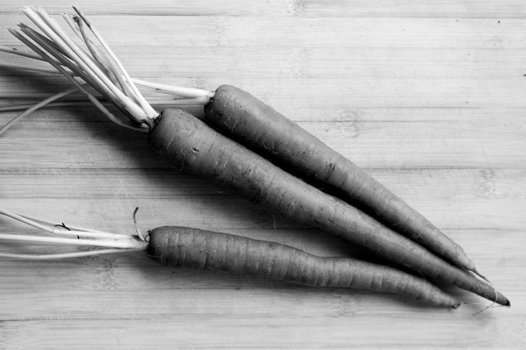 3 carrots on brown wooden table 3 carrots on brown wooden table