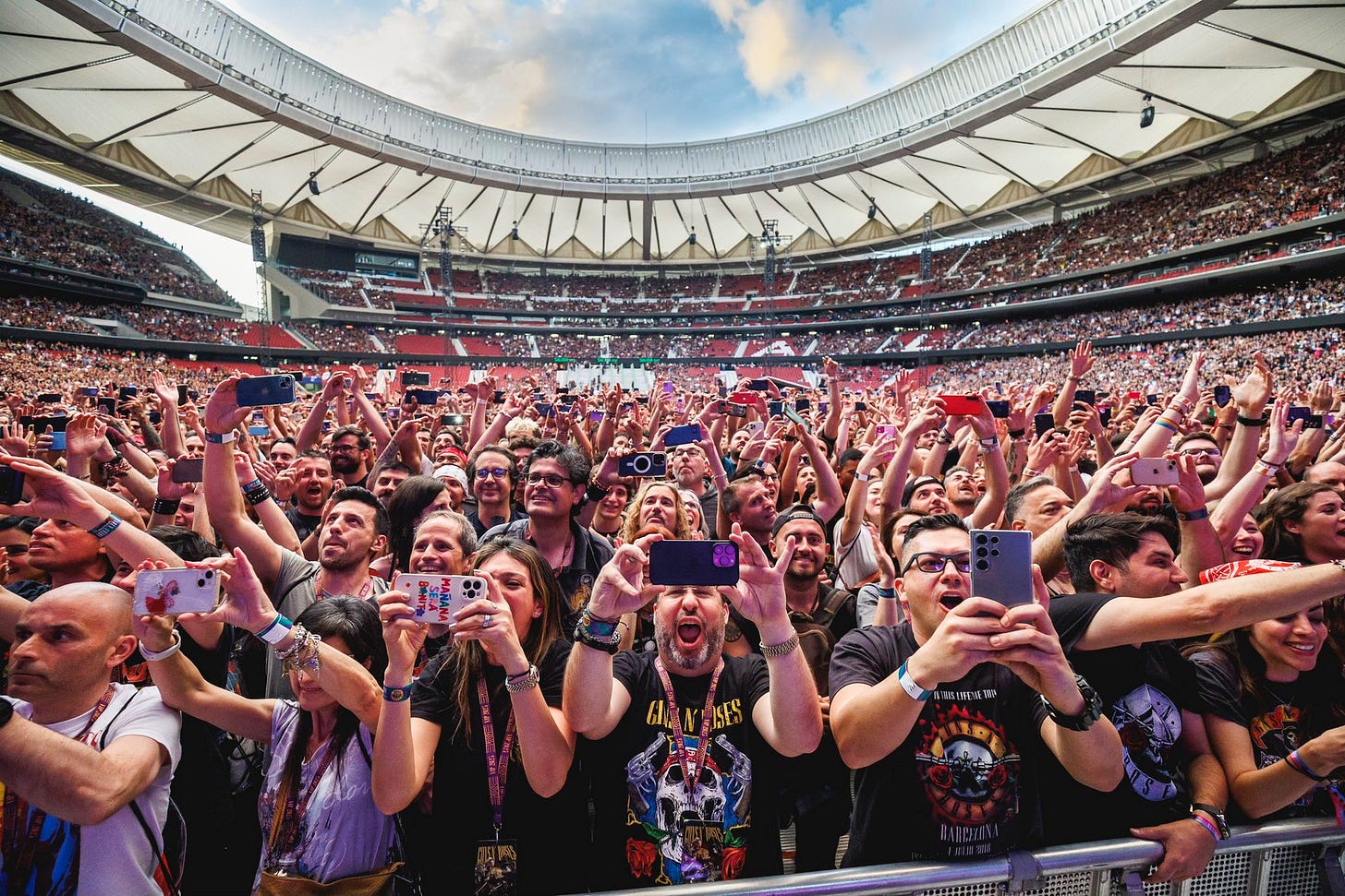 El público de un concierto feliz con sus móviles en alto El público de un concierto feliz con sus móviles en alto