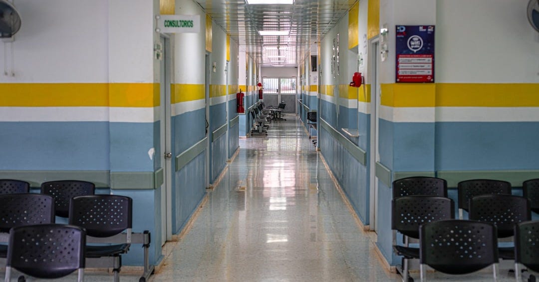 A long hallway with chairs and a clock on the wall