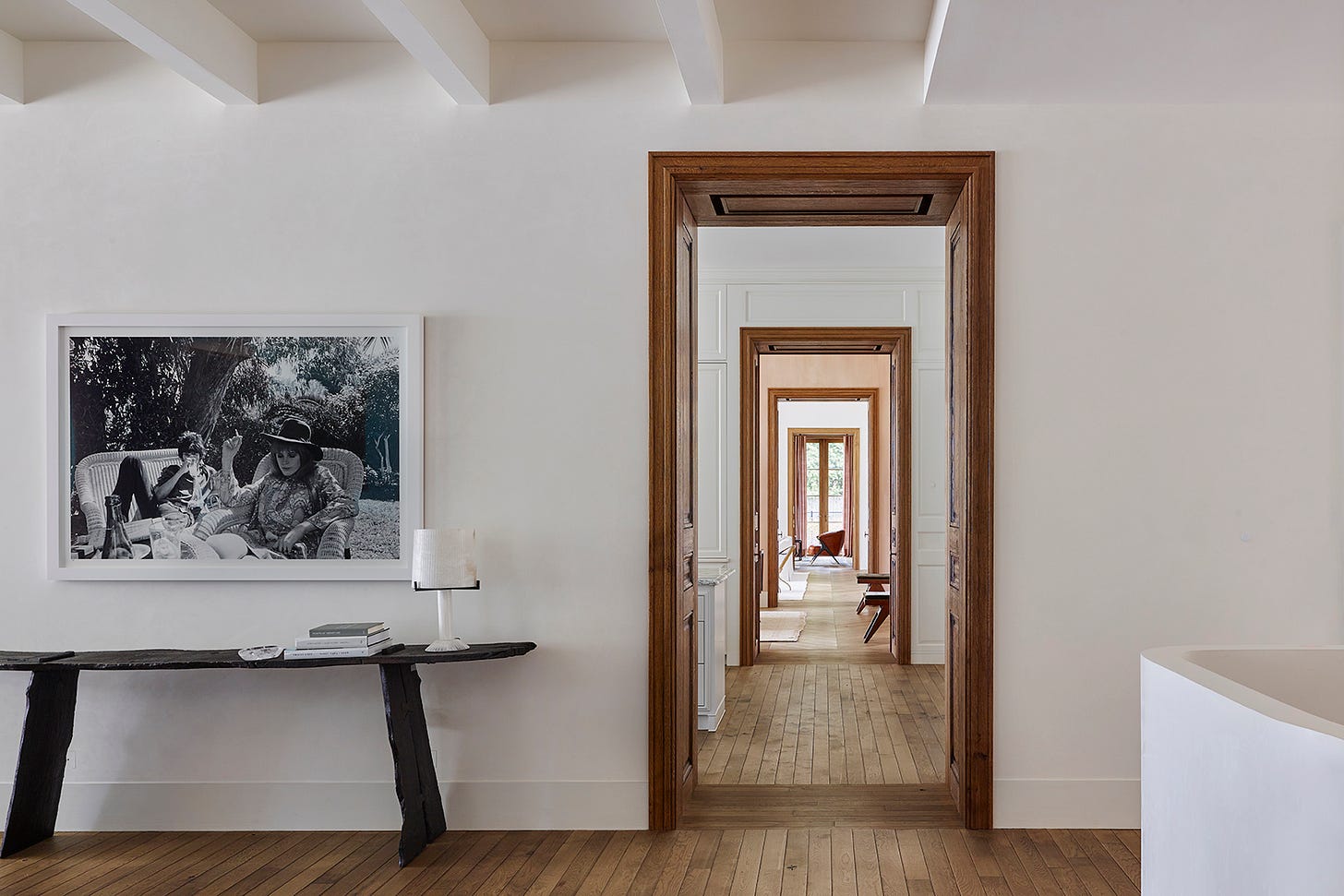 View through wood doorframe into hallway with doors