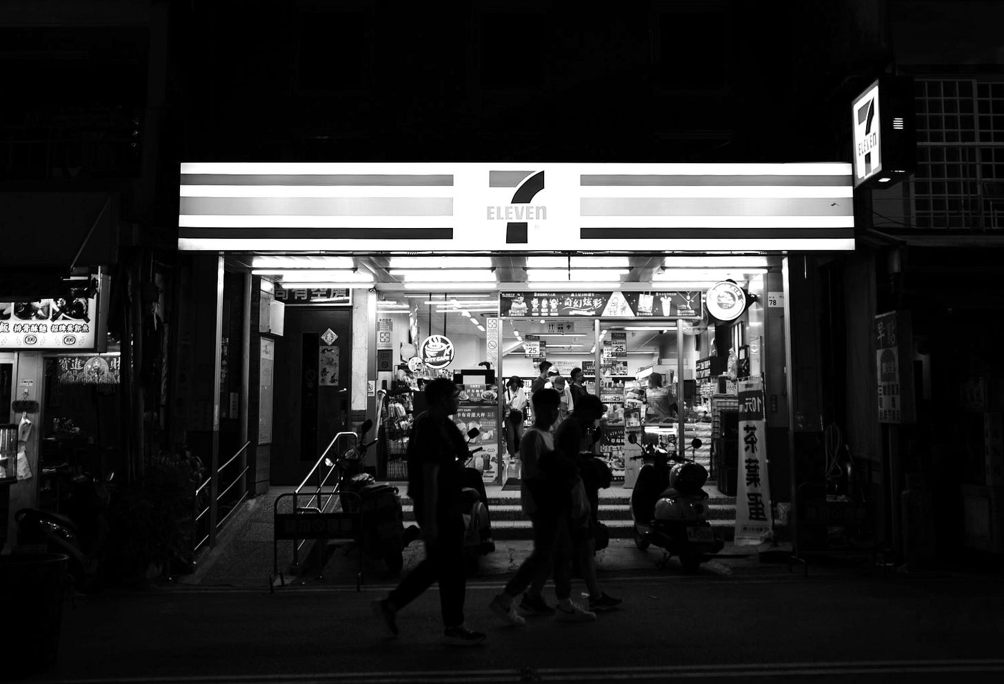 a group of people walking in front of a gas station a group of people walking in front of a gas station