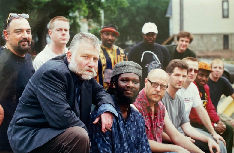 Twelve musicians gather outside and pose in two rows Twelve musicians gather outside and pose in two rows
