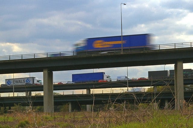 Trucks passing on an elevated roadway over marshland in Essex Trucks passing on an elevated roadway over marshland in Essex