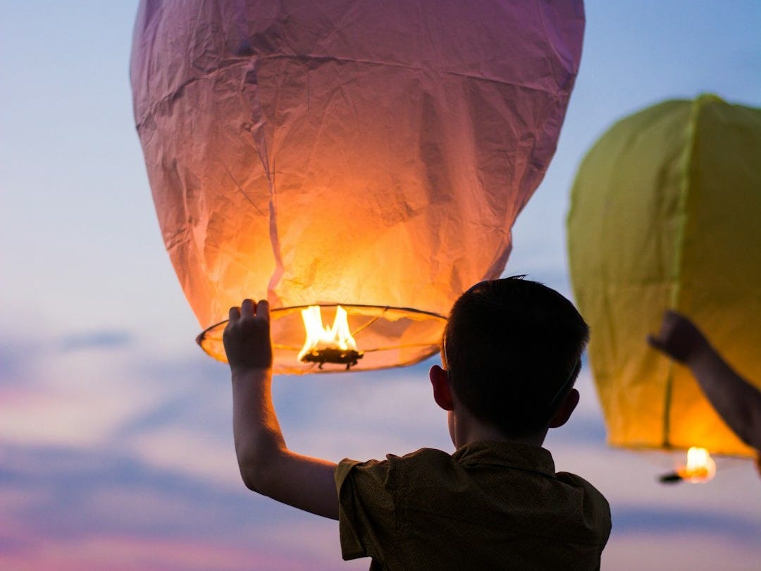 person holding yellow flammable balloon person holding yellow flammable balloon