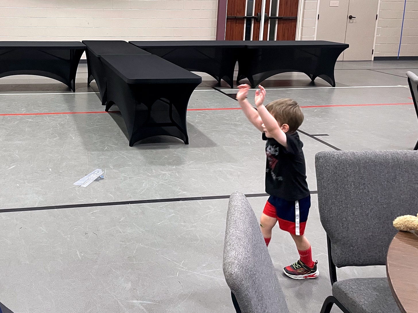 A little boy running around a gym
