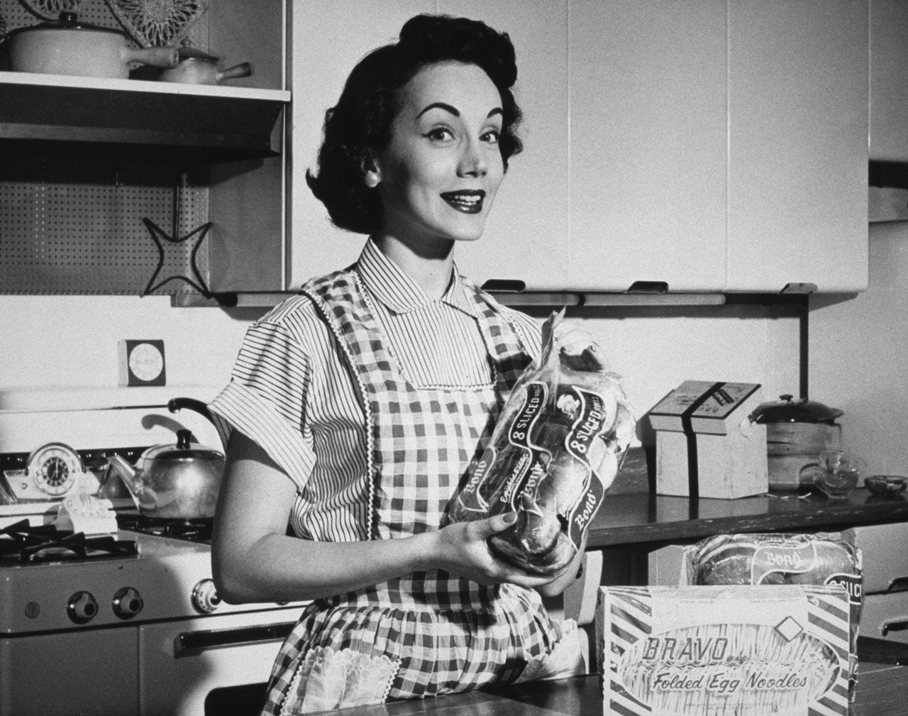 A housewife showing off a loaf of all-important sliced bread.