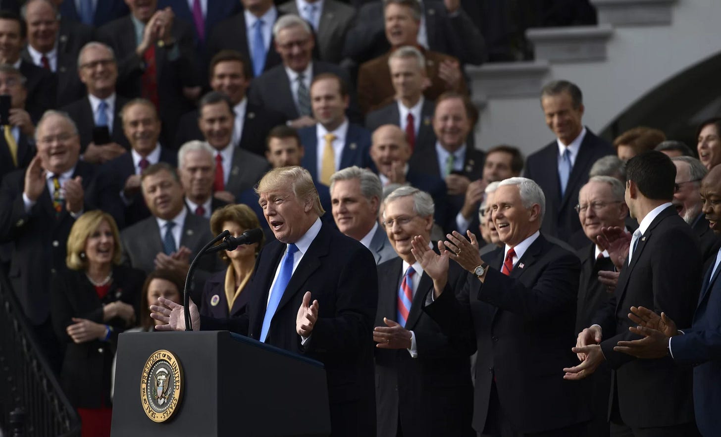 A photo of Donald Trump celebrating new corporate tax cuts in 2017. A photo of Donald Trump celebrating new corporate tax cuts in 2017.