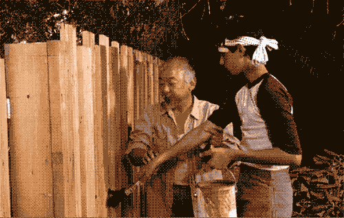 gif animado mostrando a cena do filme citado, com o mestre conduzindo a mão do aprendiz para mostrar o movimento de pintar uma cerca