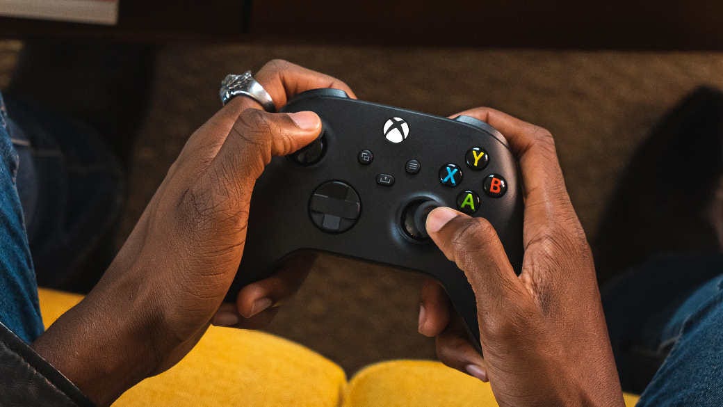 A man holding a black Xbox Wireless Controller