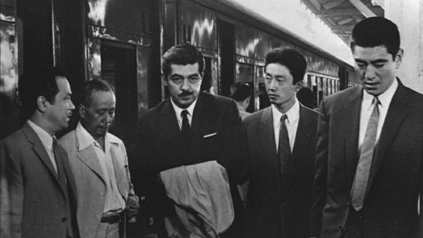 A Fugitive from the Past | Still features men outside a train.