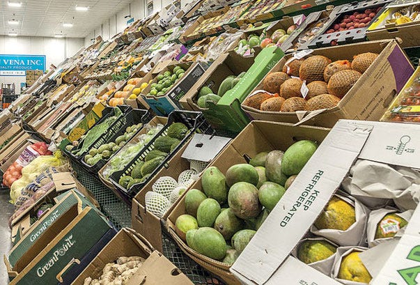 Stacks of fresh produce—fruits and vegetables—organized on pallets in a wholesale market setting, highlighting the scale, structure, and logistical flow of Canada’s food distribution system.