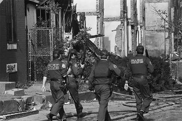 Solemn police officers patrol the devastated residential area, surveying the extensive damage a day after the bombing. Solemn police officers patrol the devastated residential area, surveying the extensive damage a day after the bombing.