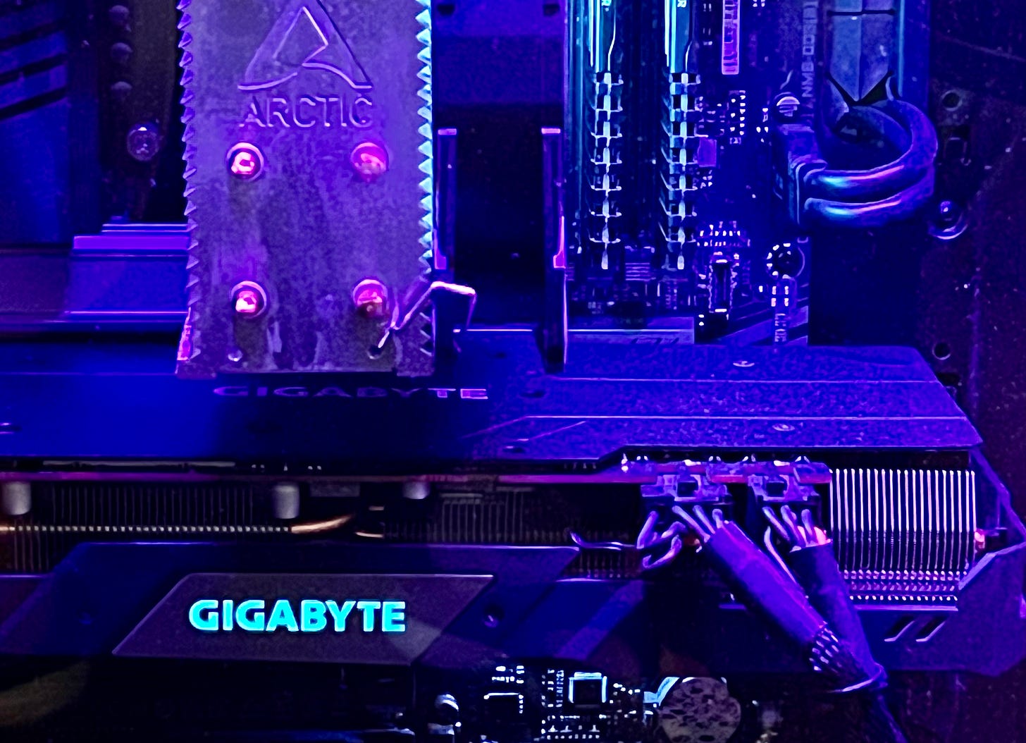 close-up of a PC's interior with cords, components, and violet lighting close-up of a PC's interior with cords, components, and violet lighting