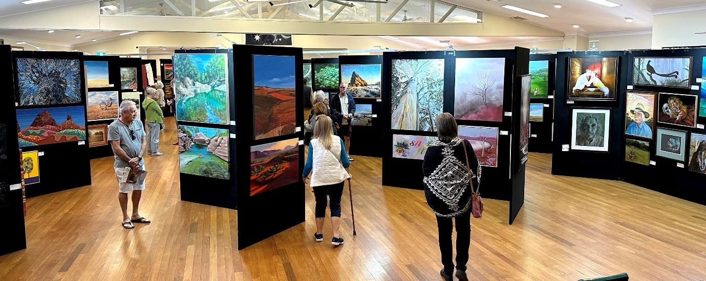 People looking at art in a room

Description automatically generated