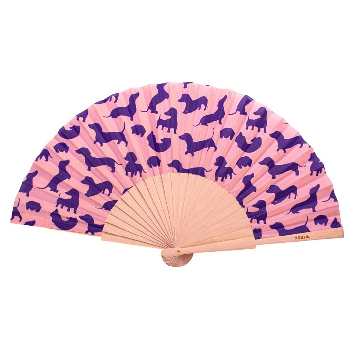 abanicos de fisura uno decorado con perros salchica de color morado y el otro con distintos helados sobre fondo rosa