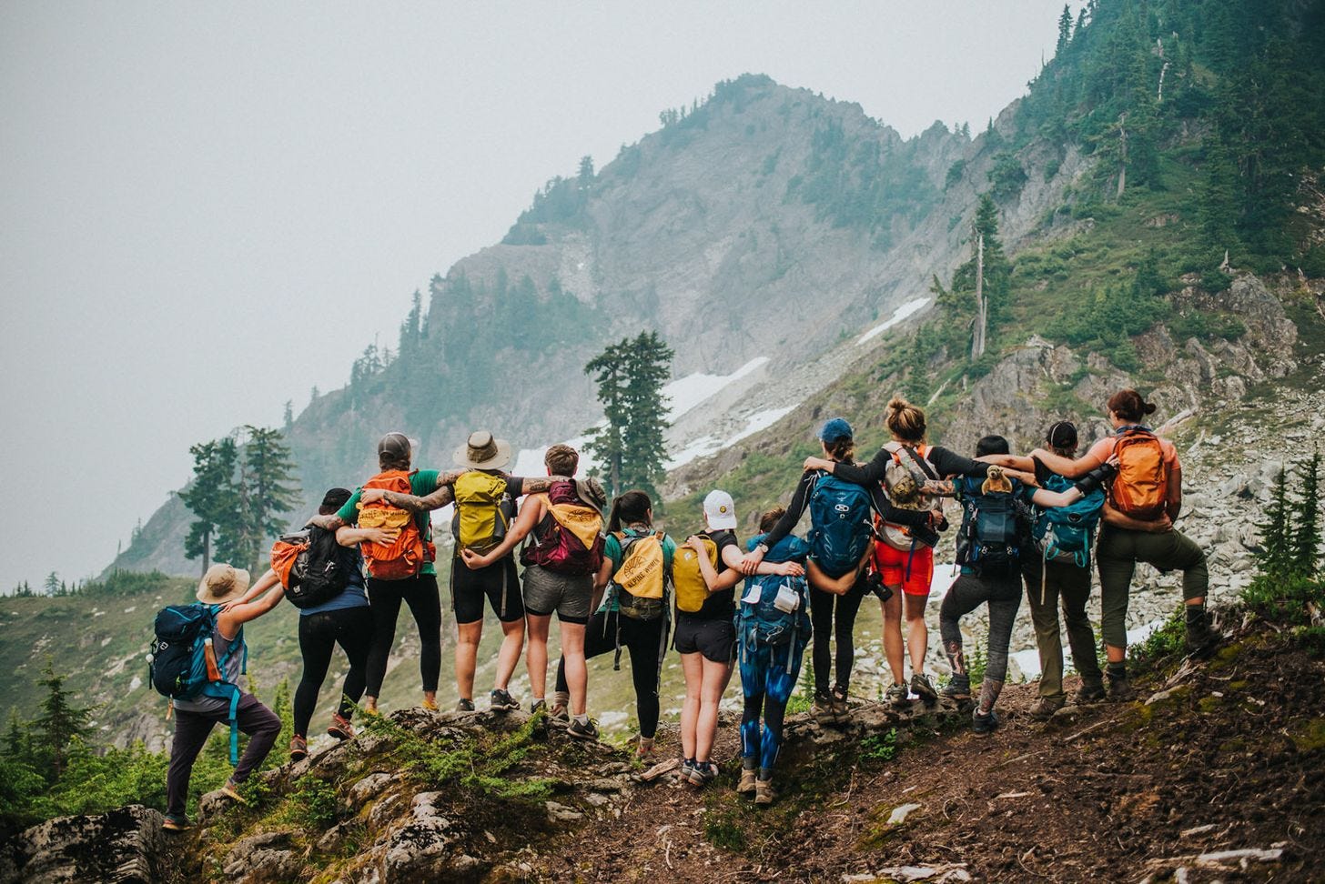 Group of women backpacking together on a mountain trail. Group of women backpacking together on a mountain trail.