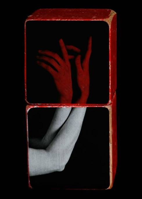 This may contain: two red blocks with hands on them against a black background, the image appears to have been altered