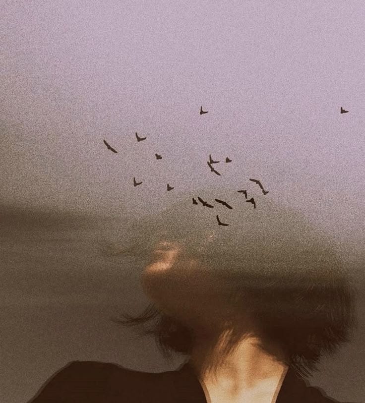 This may contain: a blurry photo of a woman with birds flying overhead in the sky above her