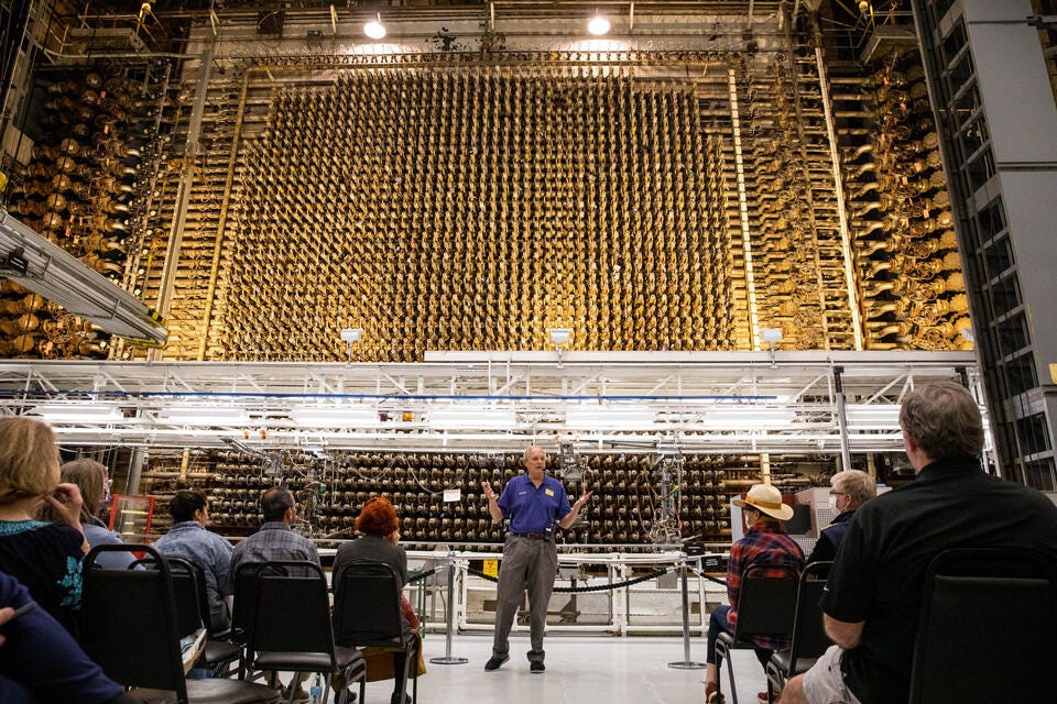 Visitors listen to guide Rick Bond as they stand before the front face of the plutonium reactor in the Hanford B Reactor in 2022. The B Reactor was the first full-scale plutonium production reactor in the world.