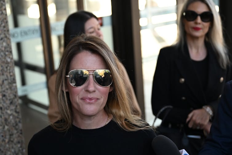 A woman wears mirrored aviator sunglasses outside court A woman wears mirrored aviator sunglasses outside court