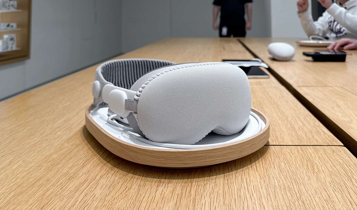 Apple Vision Pro with a cover glass cover sitting in a rounded tray on a store table.