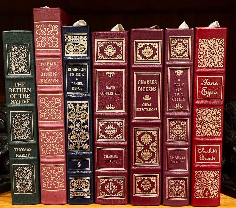 May include: A row of seven classic literature books with burgundy and green covers. The titles include 'The Return of the Native' by Thomas Hardy, 'Poems of John Keats', 'Robinson Crusoe' by Daniel Defoe, 'David Copperfield' by Charles Dickens, 'Great Expectations' by Charles Dickens, 'A Tale of Two Cities' by Charles Dickens, and 'Jane Eyre' by Charlotte Brontë. May include: A row of seven classic literature books with burgundy and green covers. The titles include 'The Return of the Native' by Thomas Hardy, 'Poems of John Keats', 'Robinson Crusoe' by Daniel Defoe, 'David Copperfield' by Charles Dickens, 'Great Expectations' by Charles Dickens, 'A Tale of Two Cities' by Charles Dickens, and 'Jane Eyre' by Charlotte Brontë.