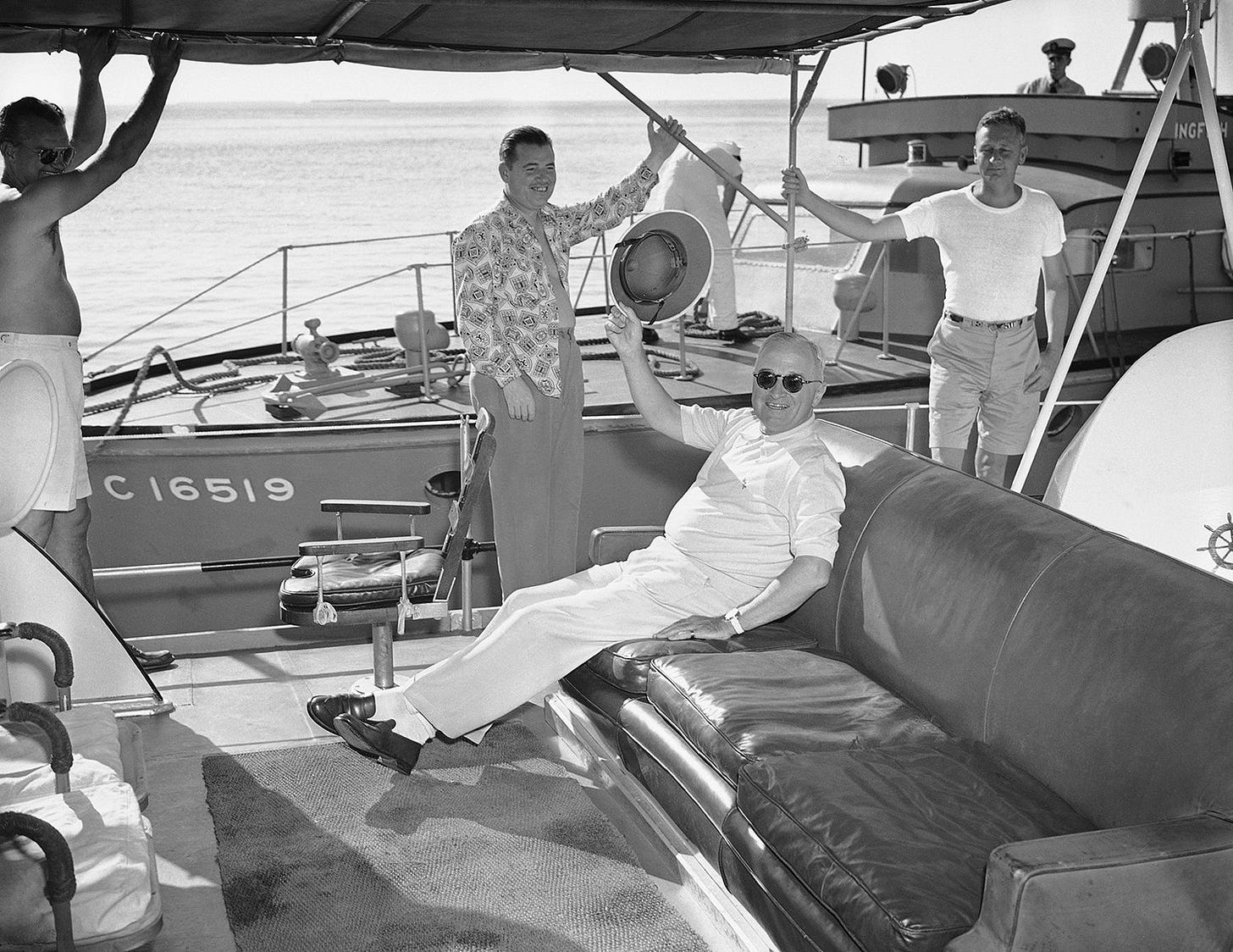 President Harry S. Truman waves his pith helmet from a Navy crash boat after a successful fishing expedition from Key West, Fla., on March 18, 1949. He famously caught a 16-pound barracuda and grouper.