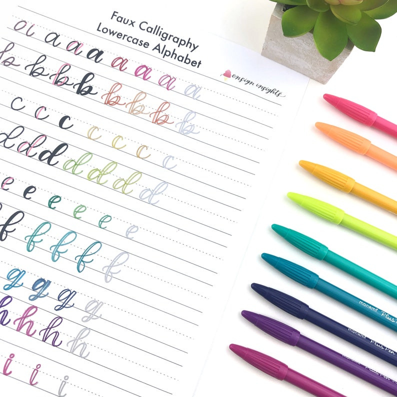 May include: A sheet of paper with the words "Faux Calligraphy Lowercase Alphabet" printed at the top. The sheet is divided into lines with lowercase letters written in cursive on each line. The letters are written in different colors, including pink, purple, blue, green, yellow, and orange. There are eight colorful pens on a white surface next to the sheet of paper.