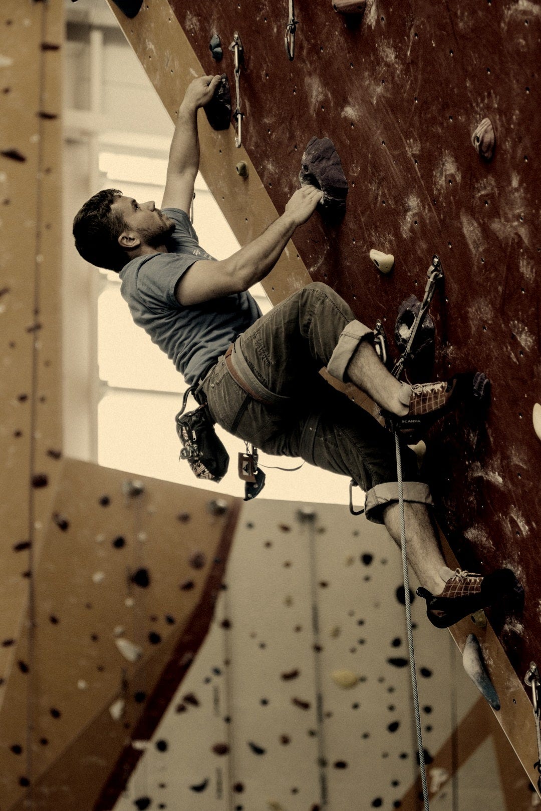 man wall climbing on red wall man wall climbing on red wall