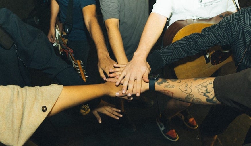 a group of people holding hands in a circle
