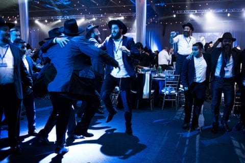 men in suits and hats dancing in blueish light