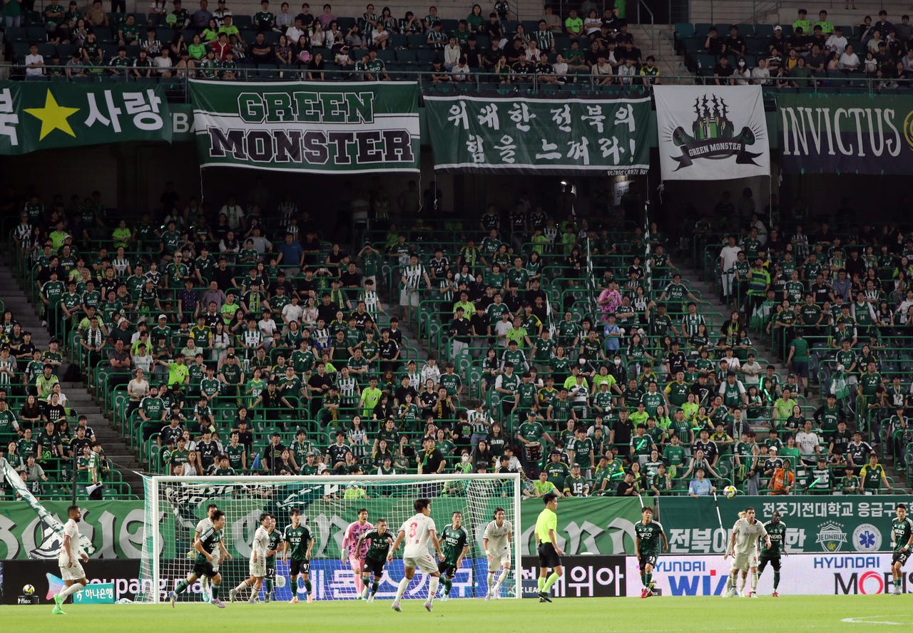 Fans of Jeonbuk Hyundai Motors cheer on their team during a Hana Bank K-League match between Jeonbuk Hyundai Motors and Suwon FC at the Jeonju World Cup Stadium on Tuesday. (Yonhap)