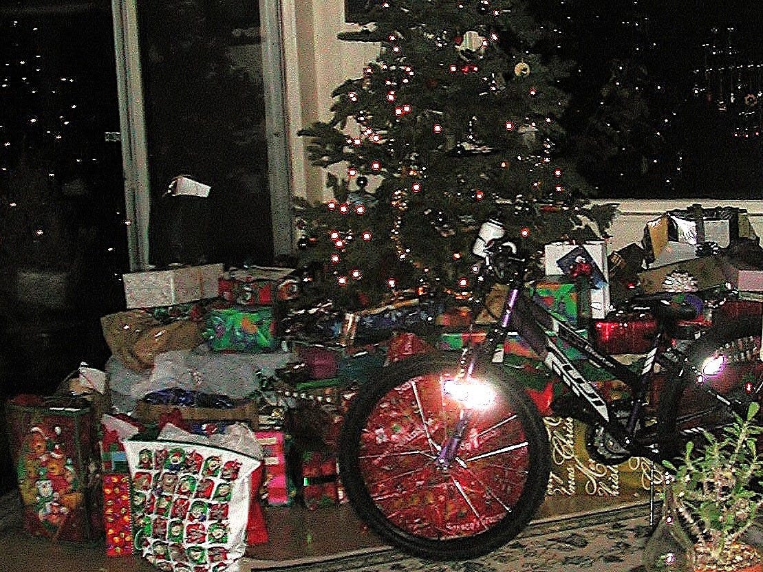 phot of a huge number of presents under a lighted christmas tree