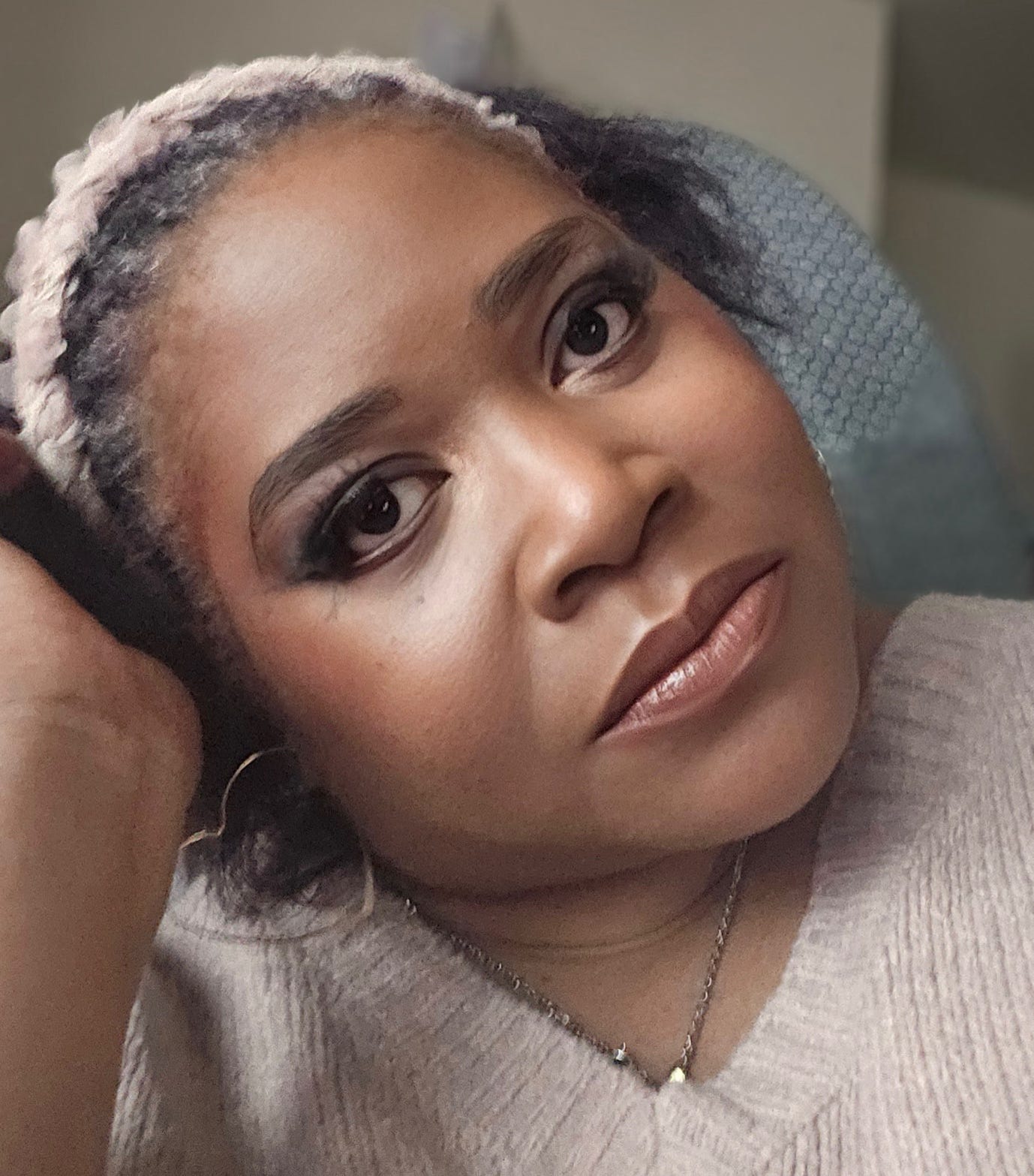 A person with braided hair and a necklace