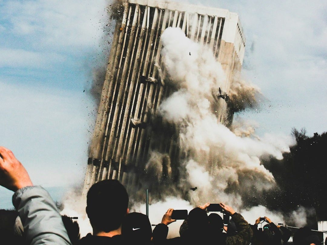 people taking photo of collapsing building