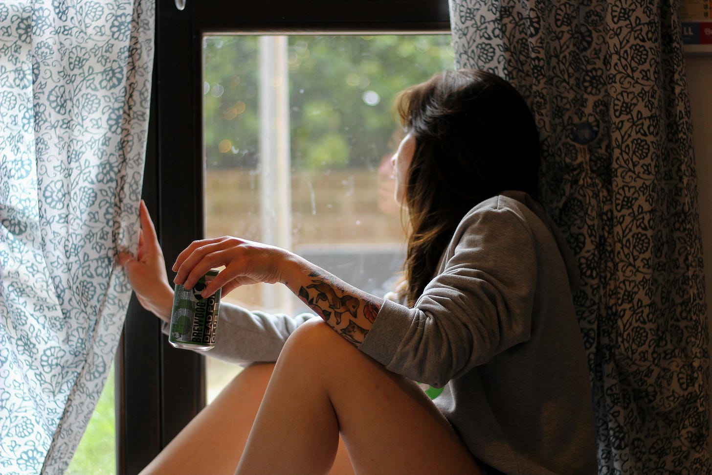 A woman gazes out of her window, waiting for the mail to be delivered