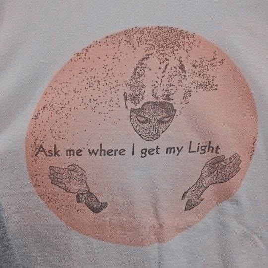 This may contain: a white t - shirt with an image of two hands and the words ask me where i get my light This may contain: a white t - shirt with an image of two hands and the words ask me where i get my light