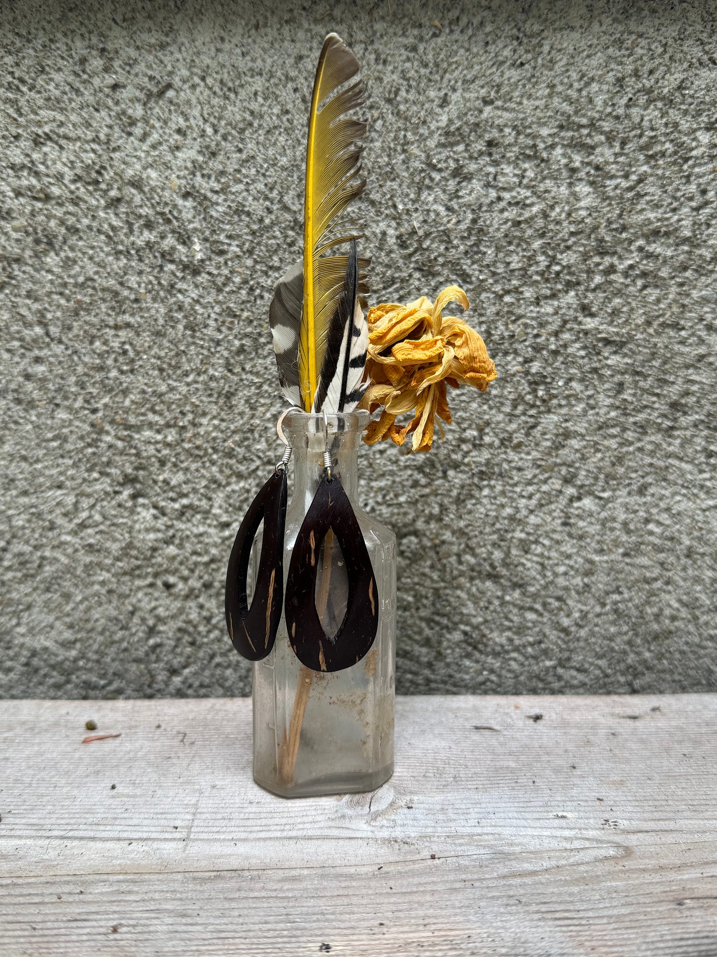 jar with coconut earrings and feather inside jar with coconut earrings and feather inside