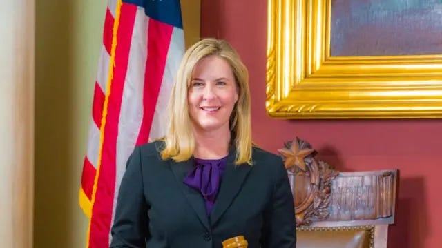 Melissa Hortman smiles wearing a blazer and purple top.