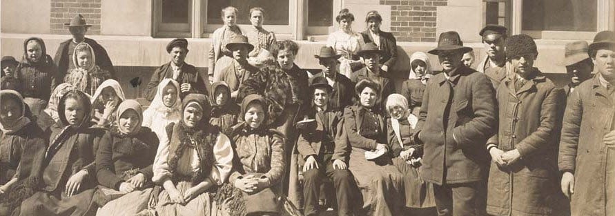 Photograph of a Group of Immigrants Outside a Building on Ellis Island [cropped]
