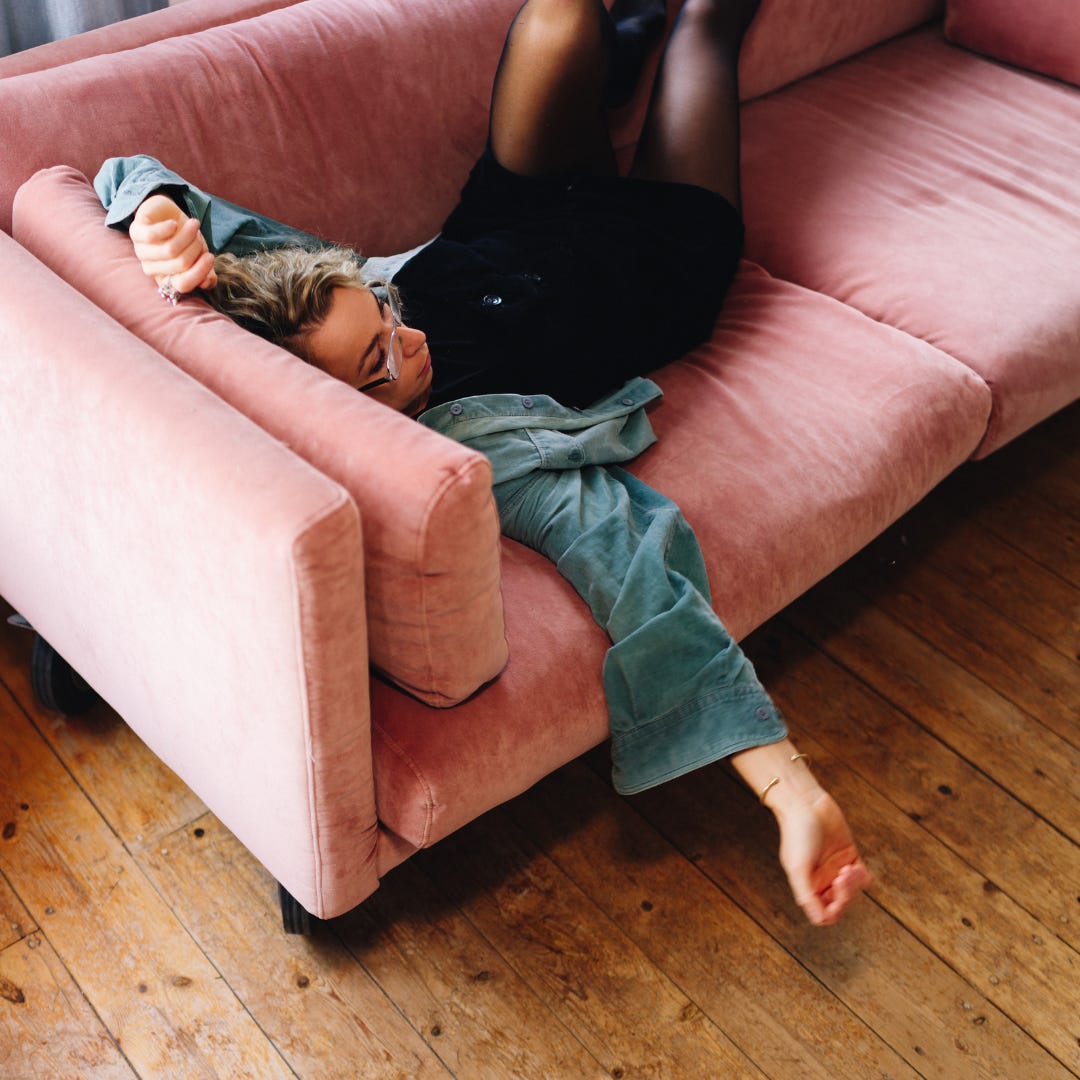 vrouw ligt ontspannen op bank in alledaags moment, zonder doel of productiviteit