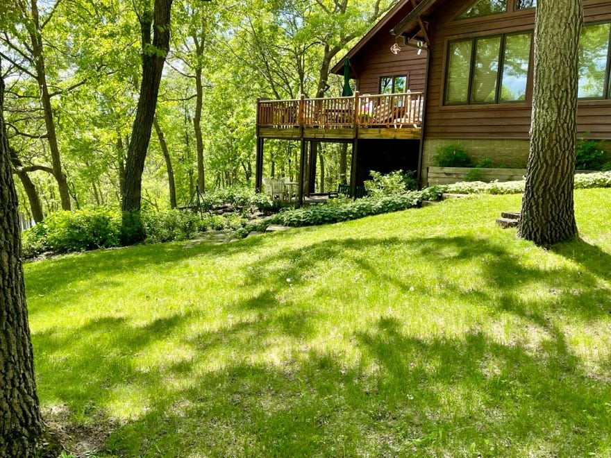 A house with a deck and a lawn

Description automatically generated