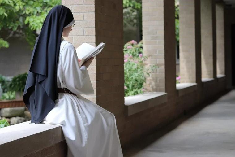The Dominican nun reads a book on the grounds of the Monastery of Our Lady of Grace in North Guilford, Connecticut.
