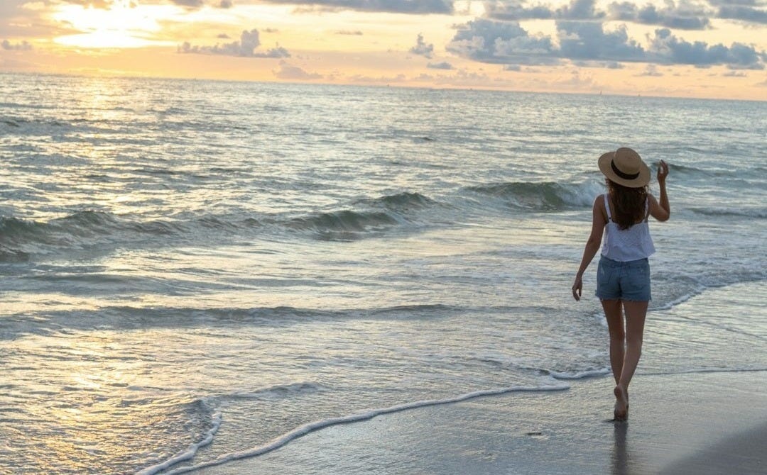 woman walking on seashore woman walking on seashore