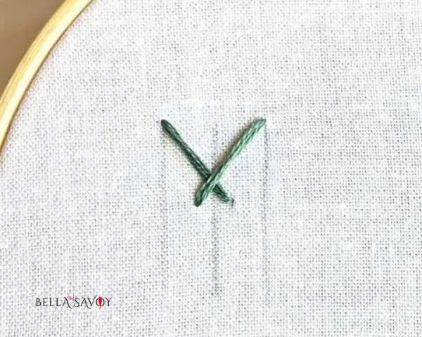 three vertical lines and an X stitched across them at the top. Lower half of the X is narrow.