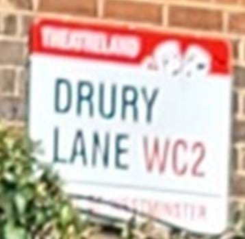 A street with a brick building and plants

AI-generated content may be incorrect.