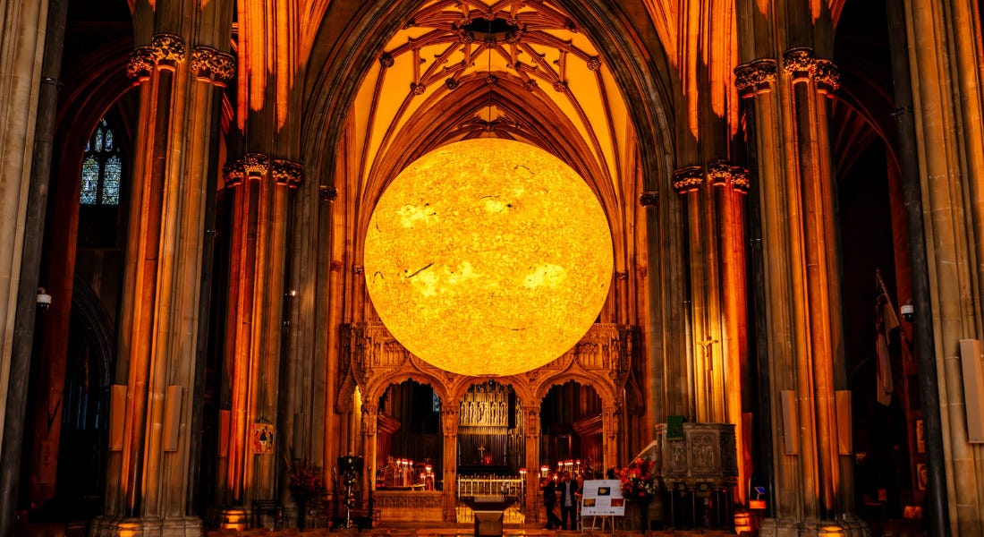 A cathedral interior with a large sun inside of it