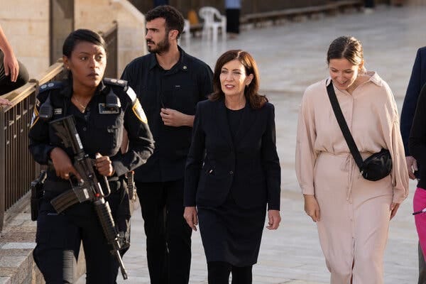Gov. Kathy Hochul walks near the Western Wall, flanked by several people. Gov. Kathy Hochul walks near the Western Wall, flanked by several people.