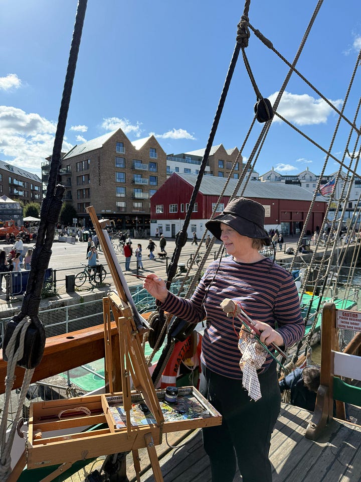 Images of 1) Gail painting on a boat, 2) the painting from the boat, 3) a view towards Bath Abbey, 4) a painting of Christmas Steps, Bristol