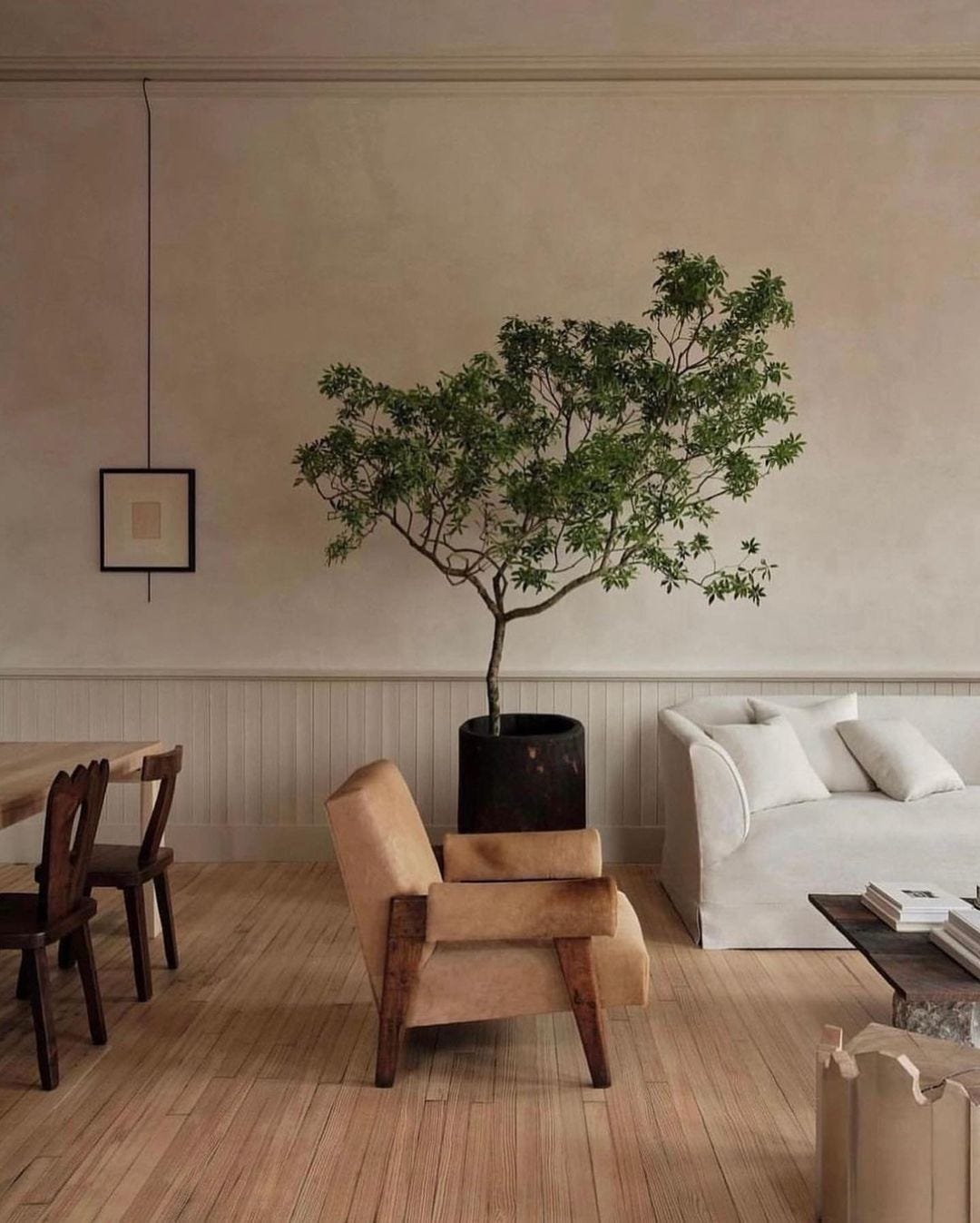 calming living room with neutral aesthetic using plants to warm the space and create a zenful feelings